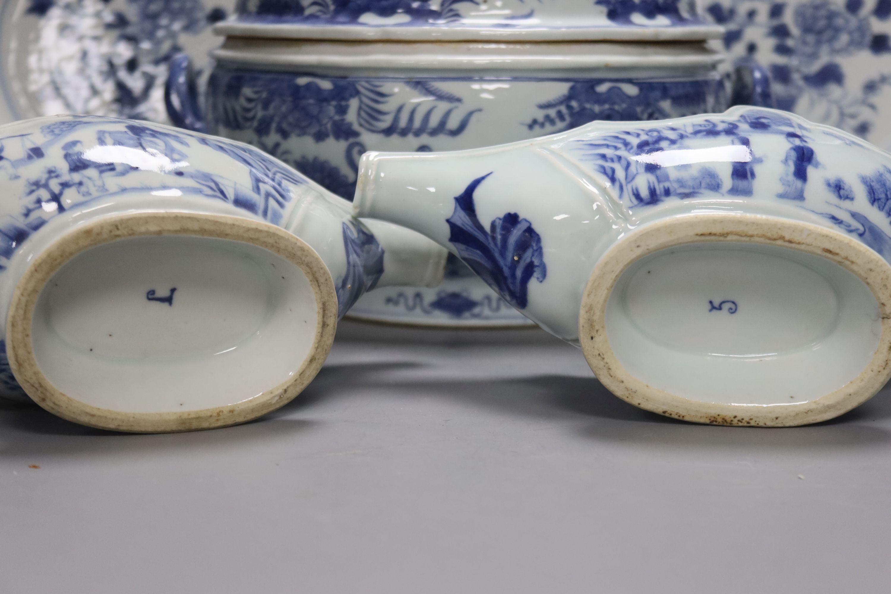 An 18th century Chinese Export blue and white octagonal tureen and cover, decorated with birds and flowers, a pair of similar sauceboats and five plates decorated with urns of flowers
